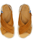 Pair of tan sandals with criss-cross straps on a white background