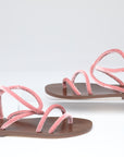 Pair of pink sandals with brown soles on a white background