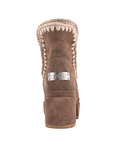 A single brown suede ankle boot shown from the back, featuring a chunky block heel, a silver-tone metal brand plate with 'nou' in script, and a braided beige trim around the collar.