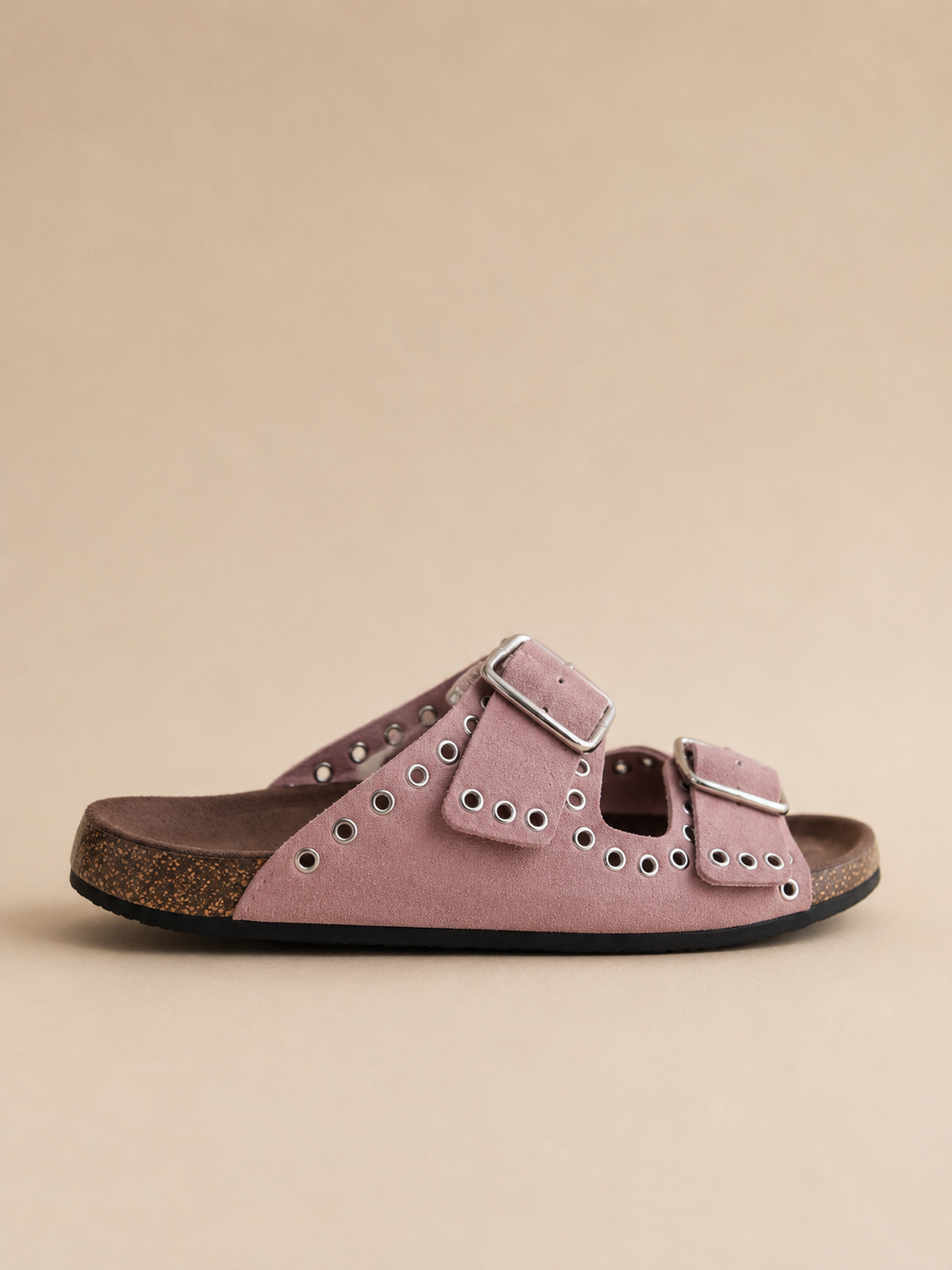 Pink sandal with a buckle on a beige background
