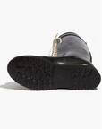 Black rubber boot with a white sole on a white background