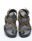 Pair of green sandals with criss-cross straps on a white background