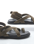 Pair of sandals with brown straps and black soles on a white background