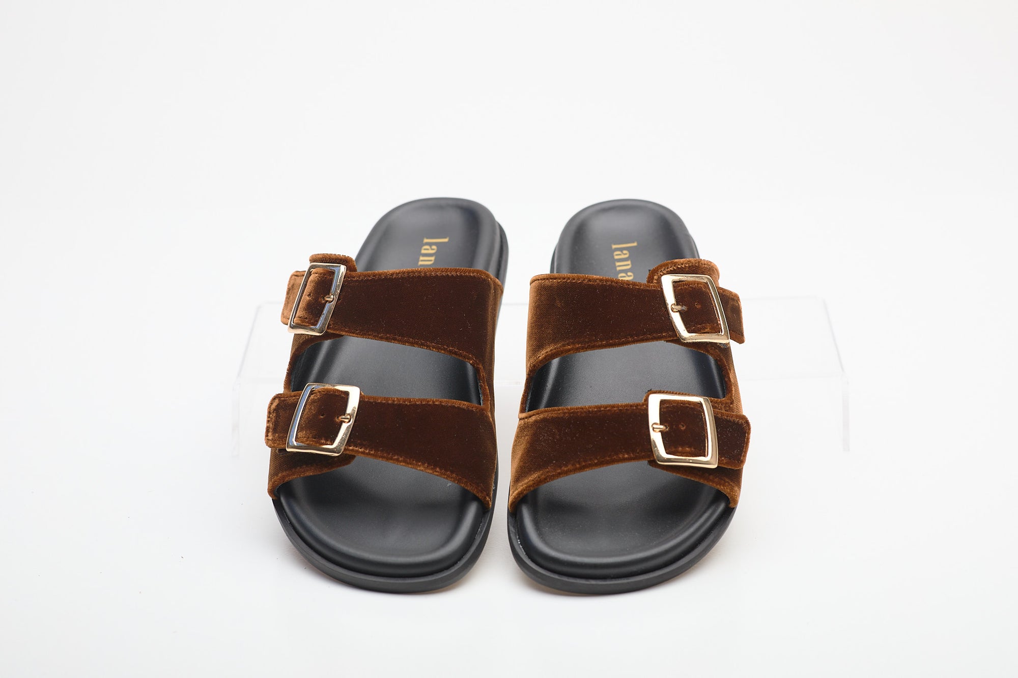 Pair of brown sandals with buckles on a white background
