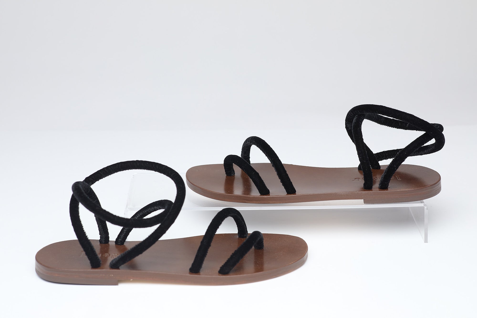 Pair of sandals with black straps on a white background