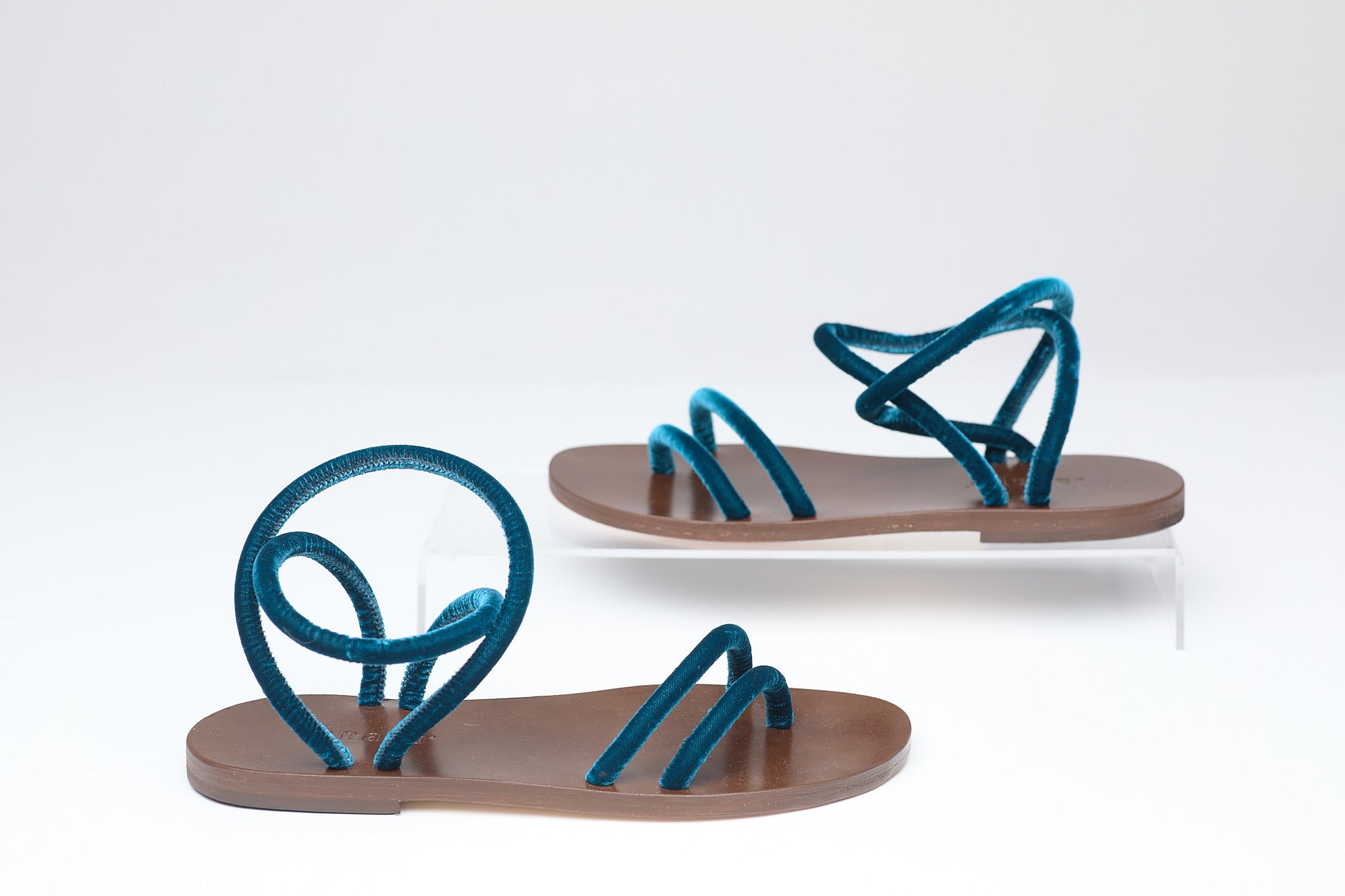 Pair of sandals with blue straps on a white background