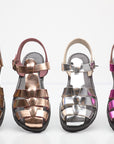 Four pairs of metallic sandals in different colors on a white background