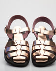 Pair of rose gold sandals on a white background