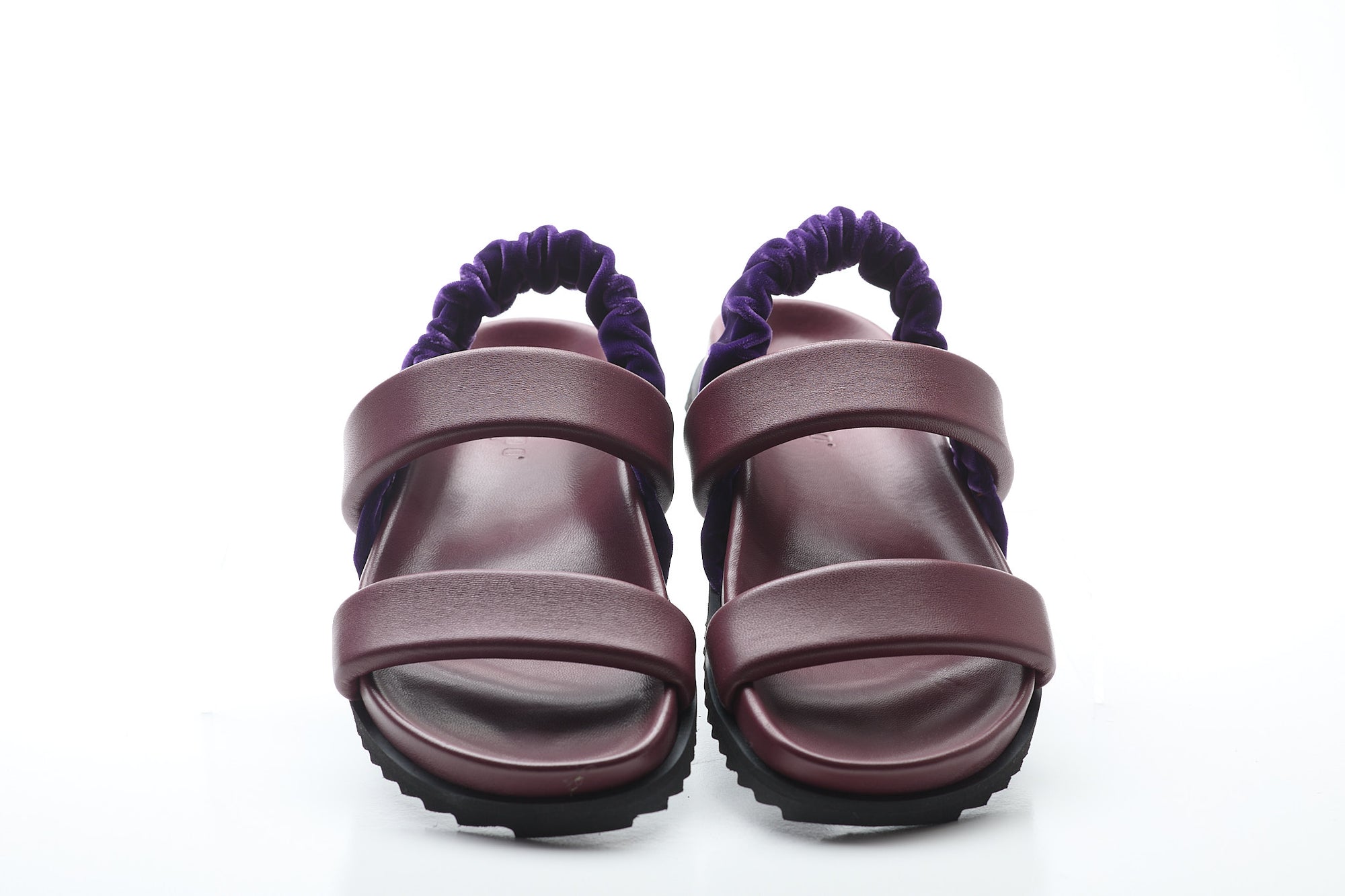 Pair of purple sandals with a white background