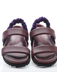 Pair of purple sandals with a white background