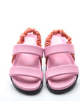 Pink sandals with orange straps on a white background