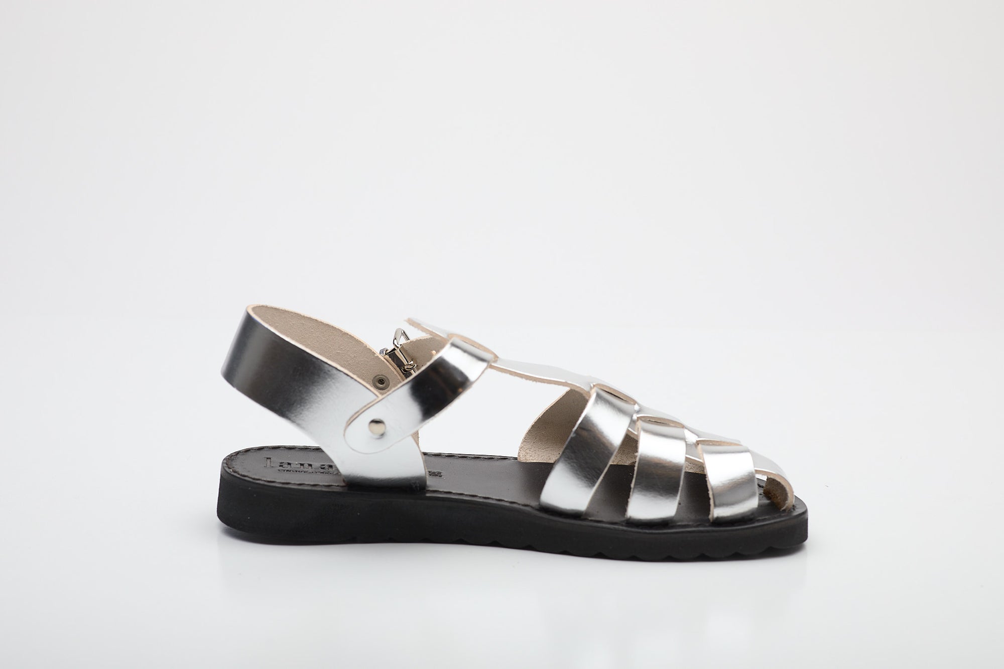 Silver sandal with black sole on a white background