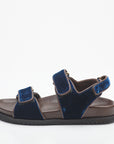 Navy sandal with brown sole on a white background