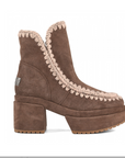 A single brown suede ankle boot with a chunky block heel, platform sole, and beige braided trim along the collar and vamp, shown in profile against a white background.