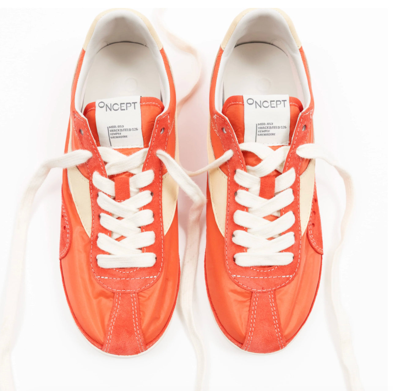 Pair of orange sneakers with white laces on a white background